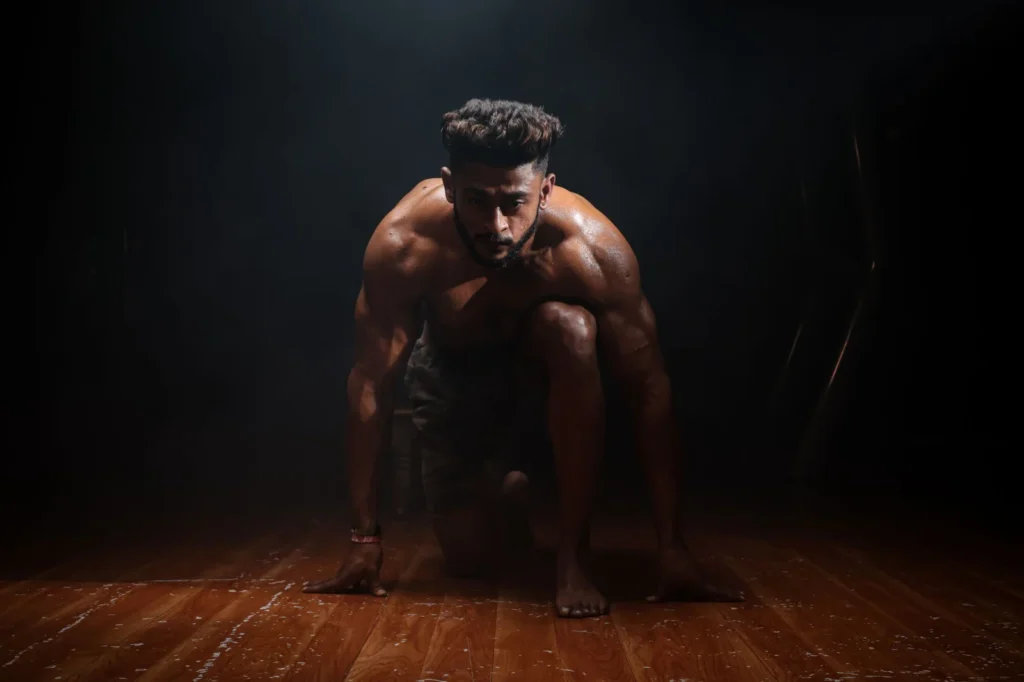 Dynamic image of a muscular man in a kneeling start position, highlighting strength and focus.