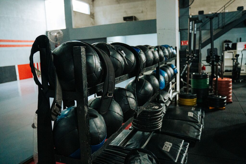 Contemporary gym space with training equipment and clients exercising