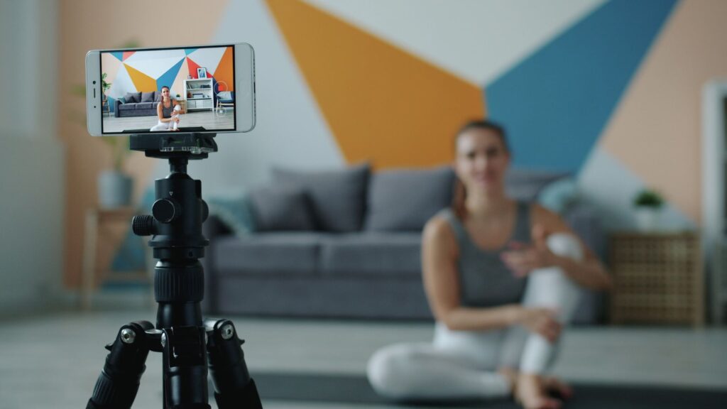 Person exercising at home with fitness coach visible on computer screen