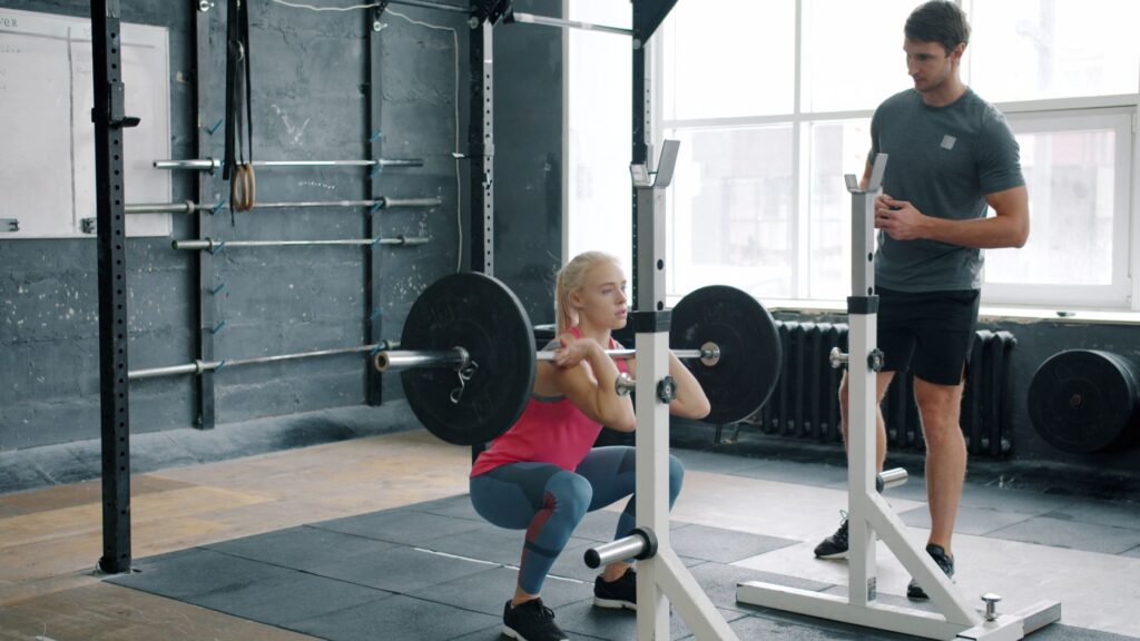 Person executing weighted squat with proper form at gym