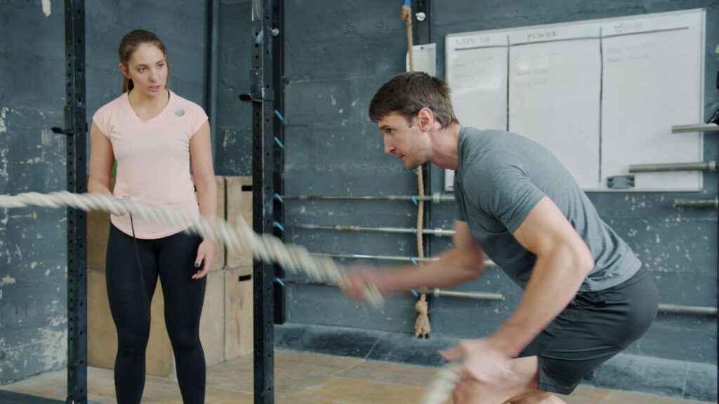 Coach guiding client through strength training movement