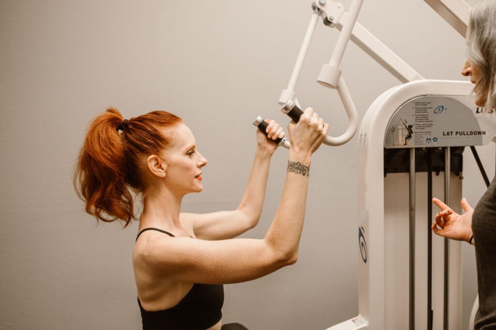 Client performing assisted exercise with trainer guidance